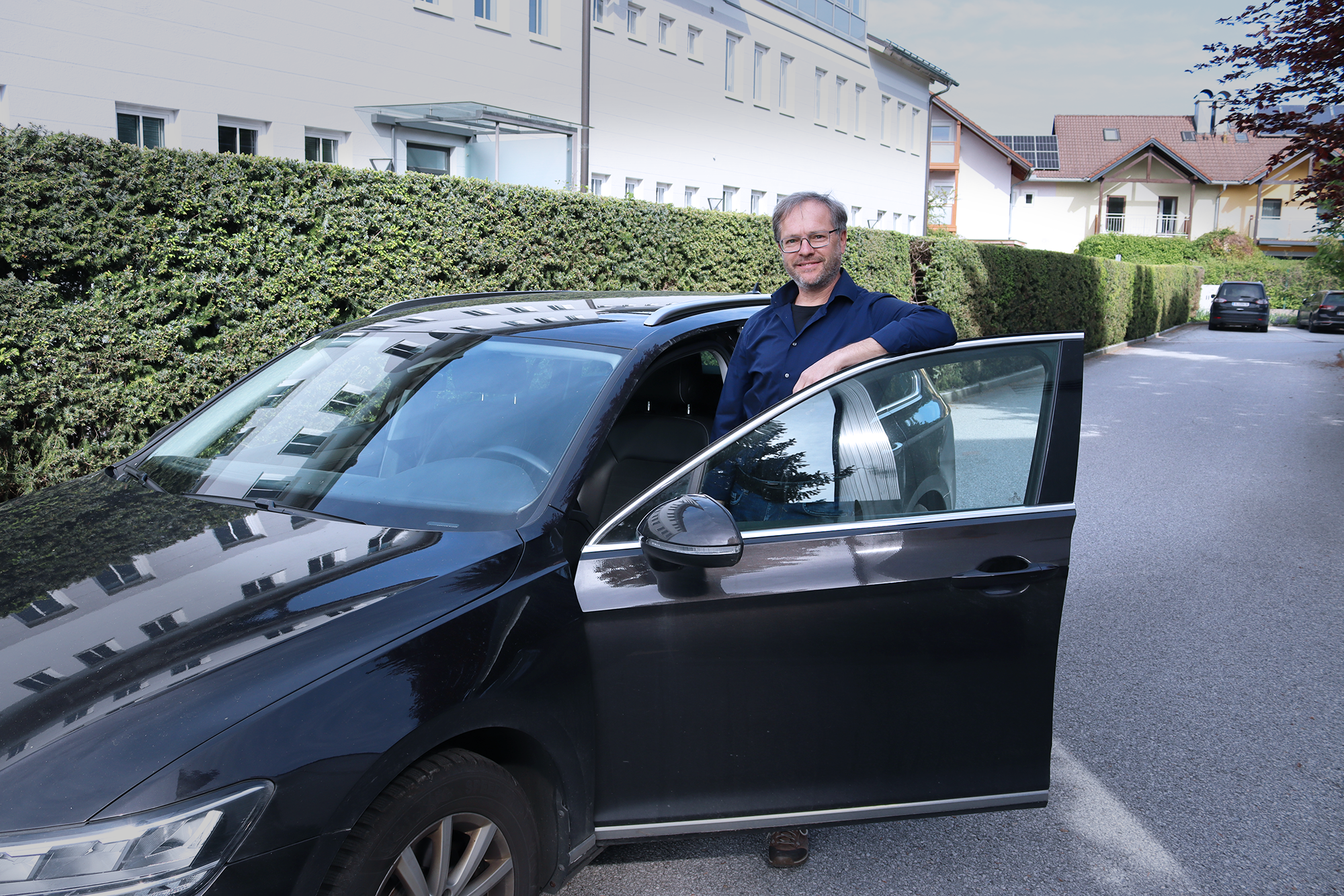 Außendienstmitarneiter steht bei Auto